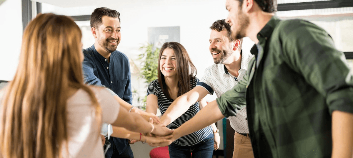 A group of people stacking their hands together, showing teamwork and unity